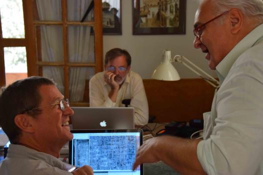 Scholar Agamemnon Tselikas and Scientist Bill Christens-Barry discuss a difficult palimpsest, while Scientist Keith Knox works in the background.  